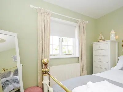 a bedroom with a bed and a window at Quay House in St Austell