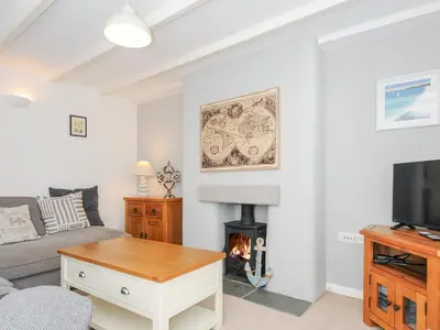 a living room with a couch and a fireplace at Quay House in St Austell