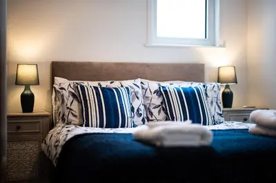 a bedroom with a bed with pillows and a window at Sandals cottage in St Ives