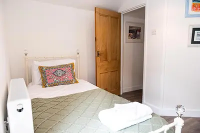 a bedroom with a bed with a pillow on it at Sandals cottage in St Ives