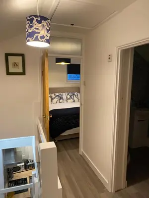 a small bedroom with a bed and a light at Sandals cottage in St Ives