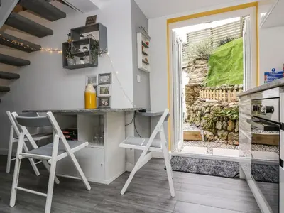 a kitchen with two chairs and a table and a window at The Hideaway in Chacewater