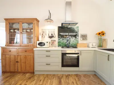 a kitchen with white cabinets and a stove top oven at The Forge in Falmouth