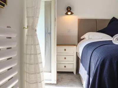 a bedroom with a bed and a dresser and a window at The Forge in Falmouth
