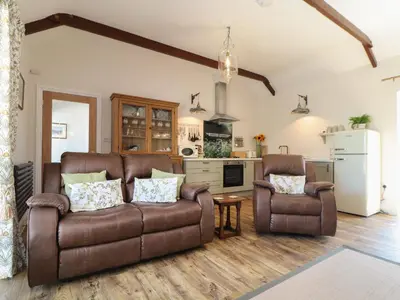 a living room with a couch and two chairs at The Forge in Falmouth