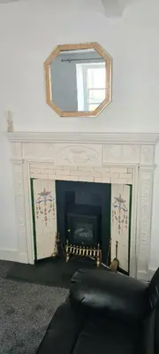 a living room with a fireplace and a mirror at Fore Street Bodmin in Bodmin