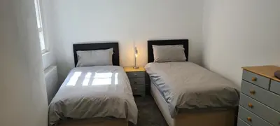 a bedroom with two beds and a dresser with a lamp at Fore Street Bodmin in Bodmin
