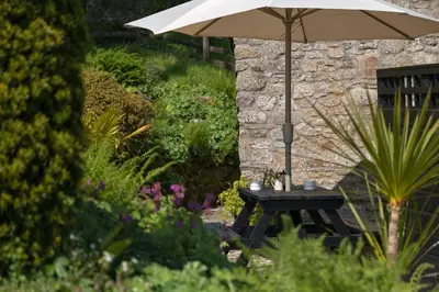 an umbrella sitting on a table in a garden at The Lambing Shed, Cornwall in Altarnun