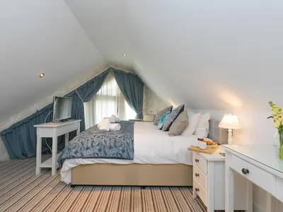 a bedroom with a large bed and a window at Porthminster Penthouse in St Ives