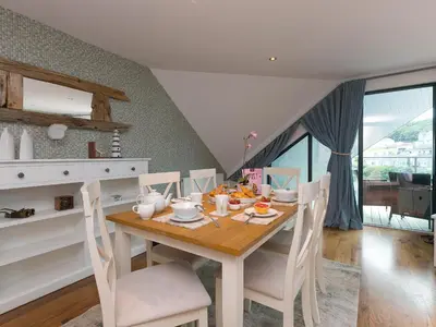 a dining room with a wooden table and chairs at Porthminster Penthouse in St Ives