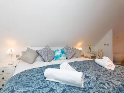 a bedroom with a large bed with towels on it at Porthminster Penthouse in St Ives