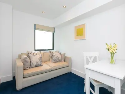 a living room with a couch and a table at Porthminster Penthouse in St Ives