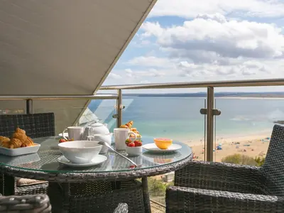 a table with food and a view of the ocean at Porthminster Penthouse in St Ives
