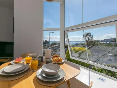 a table with plates of food on it with a window at Waters Watch in St Ives