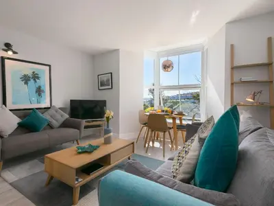 a living room with a couch and a table at Waters Watch in St Ives