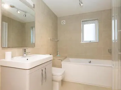 a bathroom with a sink and a toilet and a tub at Waters Watch in St Ives