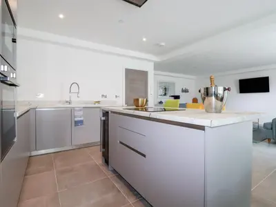 a kitchen with white counters and a large island at 30 Cliff Edge in Newquay