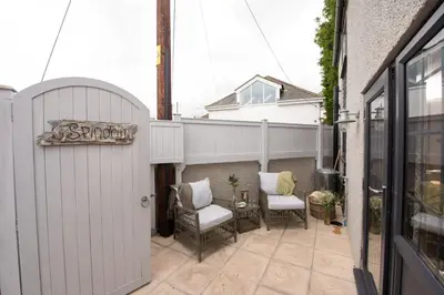a small patio with two chairs and a table at Spindrift, St Ives in St Ives