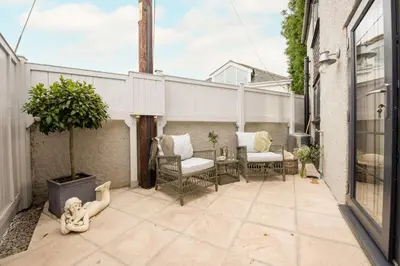 a patio with a statue of a monkey sitting on the ground at Spindrift, St Ives in St Ives