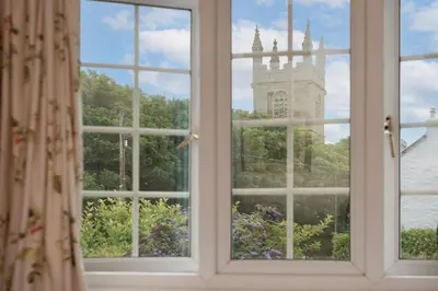 a window with a view of a clock tower at Pump Cottage in Gwithian