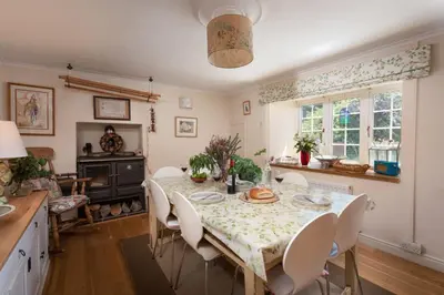 a kitchen and dining room with a table and chairs at Pump Cottage in Gwithian