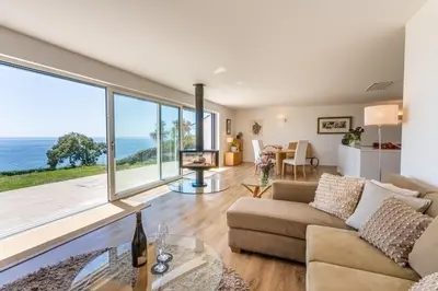 a living room with a couch and a view of the ocean at Finest Retreats - Avalon Sea Views in Downderry
