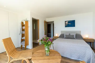 a bedroom with a bed and a vase of flowers on a table at Finest Retreats - Avalon Sea Views in Downderry