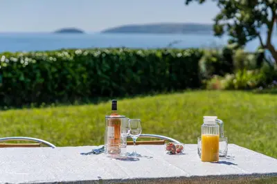 a table with glasses and bottles of orange juice on it at Finest Retreats - Avalon Sea Views in Downderry