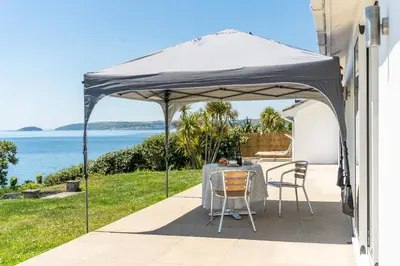 a tent on a patio with a table and chairs at Finest Retreats - Avalon Sea Views in Downderry