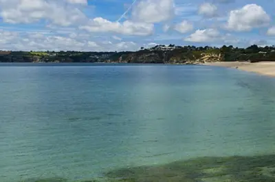 a large body of water with a sandy beach at Chy Lowen Private rooms with kitchen, dining room and garden access close to Eden Project & beaches in Saint Blazey