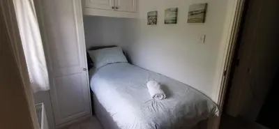 a small bed in a corner of a room at Chy Lowen Private rooms with kitchen, dining room and garden access close to Eden Project & beaches in Saint Blazey