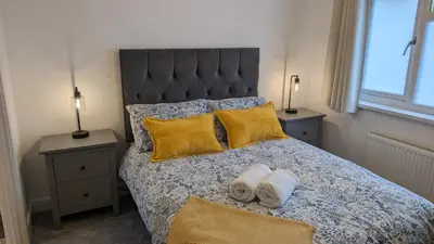 a bedroom with a bed with two towels on it at Chy Lowen Private rooms with kitchen, dining room and garden access close to Eden Project & beaches in Saint Blazey