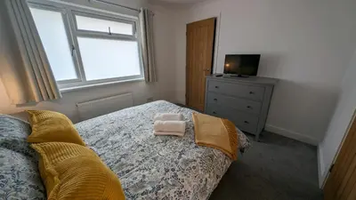 a bedroom with a bed with two towels on it at Chy Lowen Private rooms with kitchen, dining room and garden access close to Eden Project & beaches in Saint Blazey