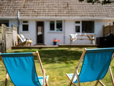 two blue chairs sitting in a yard in front of a house at Suncroft in Port Isaac