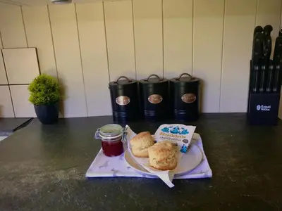 a plate of food with biscuits and jam on a table at Roosters Retreat in Launceston