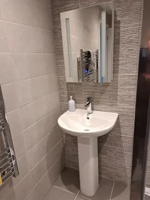 a bathroom with a sink and a mirror at 1 Chatsworth Riverscape Apartments - Riverview apartment in great location with free parking overlooking the Gannel just a short walk from Newquays incredible beaches and local amenities in Newquay