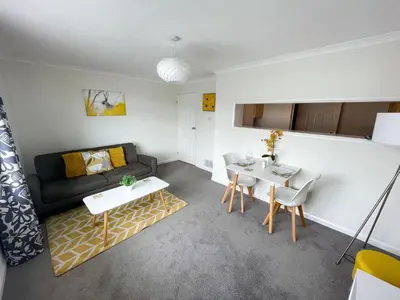 a living room with a couch and a table at 1 Chatsworth Riverscape Apartments - Riverview apartment in great location with free parking overlooking the Gannel just a short walk from Newquays incredible beaches and local amenities in Newquay