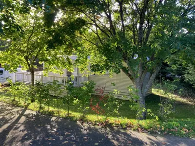 a park bench in front of a house at Tranquil Retreat at River Valley Country Park in Penzance