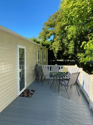 a patio with a table and chairs on a deck at Tranquil Retreat at River Valley Country Park in Penzance