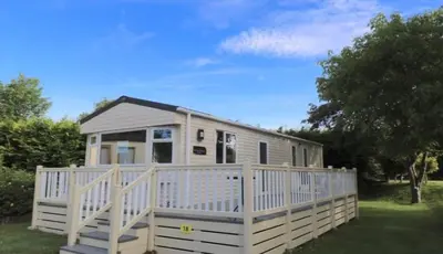 a small white house with a white fence at Tranquil Retreat at River Valley Country Park in Penzance