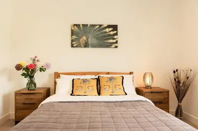 a bedroom with a large bed with two night stands at Sandy Cove in Penzance