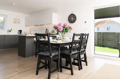 a kitchen and dining room with a table and chairs at Sandy Cove in Penzance