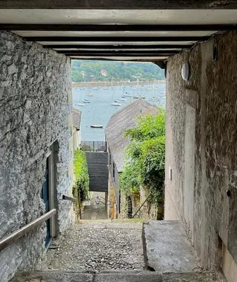 an alleyway with a view of a harbor with boats at 4 Bedroom Cottage with panoramic Harbour views in Falmouth