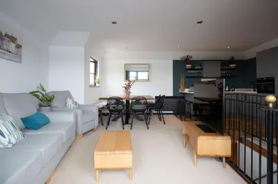 a living room with a couch and a table at 4 Bedroom Cottage with panoramic Harbour views in Falmouth