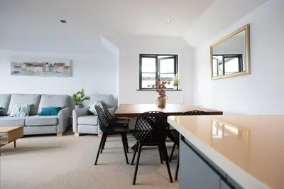 a kitchen and living room with a table and chairs at 4 Bedroom Cottage with panoramic Harbour views in Falmouth