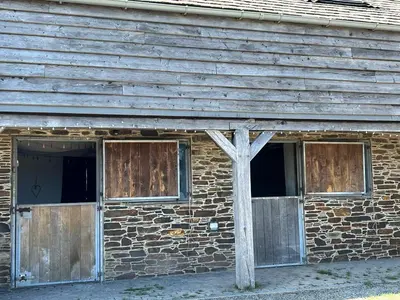 an old brick building with boarded up windows at Number Four - The Old Stable Block in Wadebridge