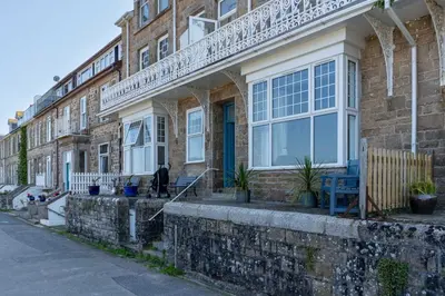 a brick building with a porch on a street at Sea Bre in St Ives
