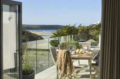 a table on a balcony with a view of the ocean at Treheyl, Pentire, Newquay in Newquay