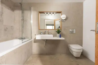 a bathroom with a sink and a toilet and a mirror at Treheyl, Pentire, Newquay in Newquay