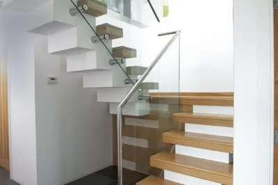 a staircase with glass railings in a house at Treheyl, Pentire, Newquay in Newquay